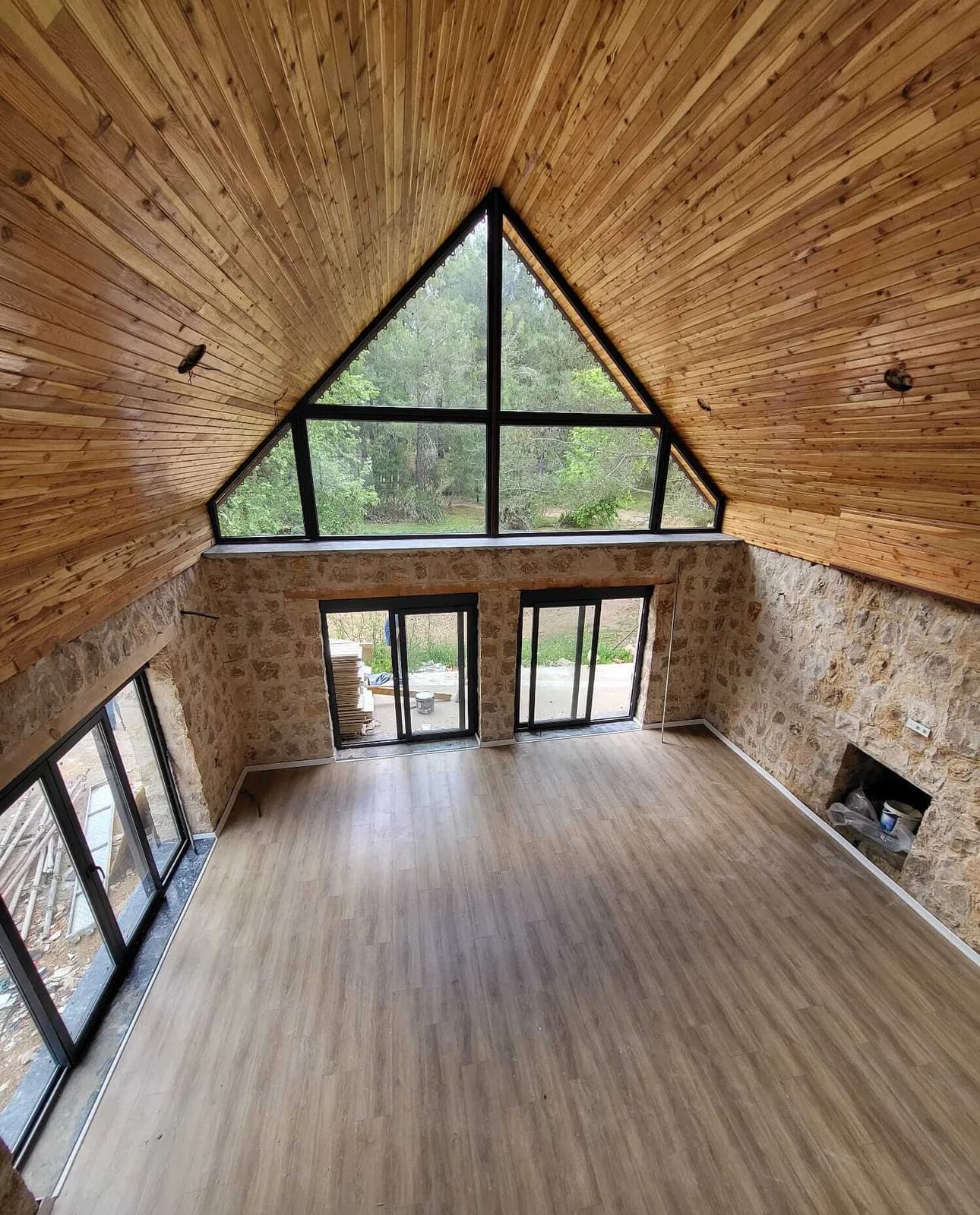 Ahşap tavanlı A-frame iç mekân, üçgen cephe camı — Bodrum